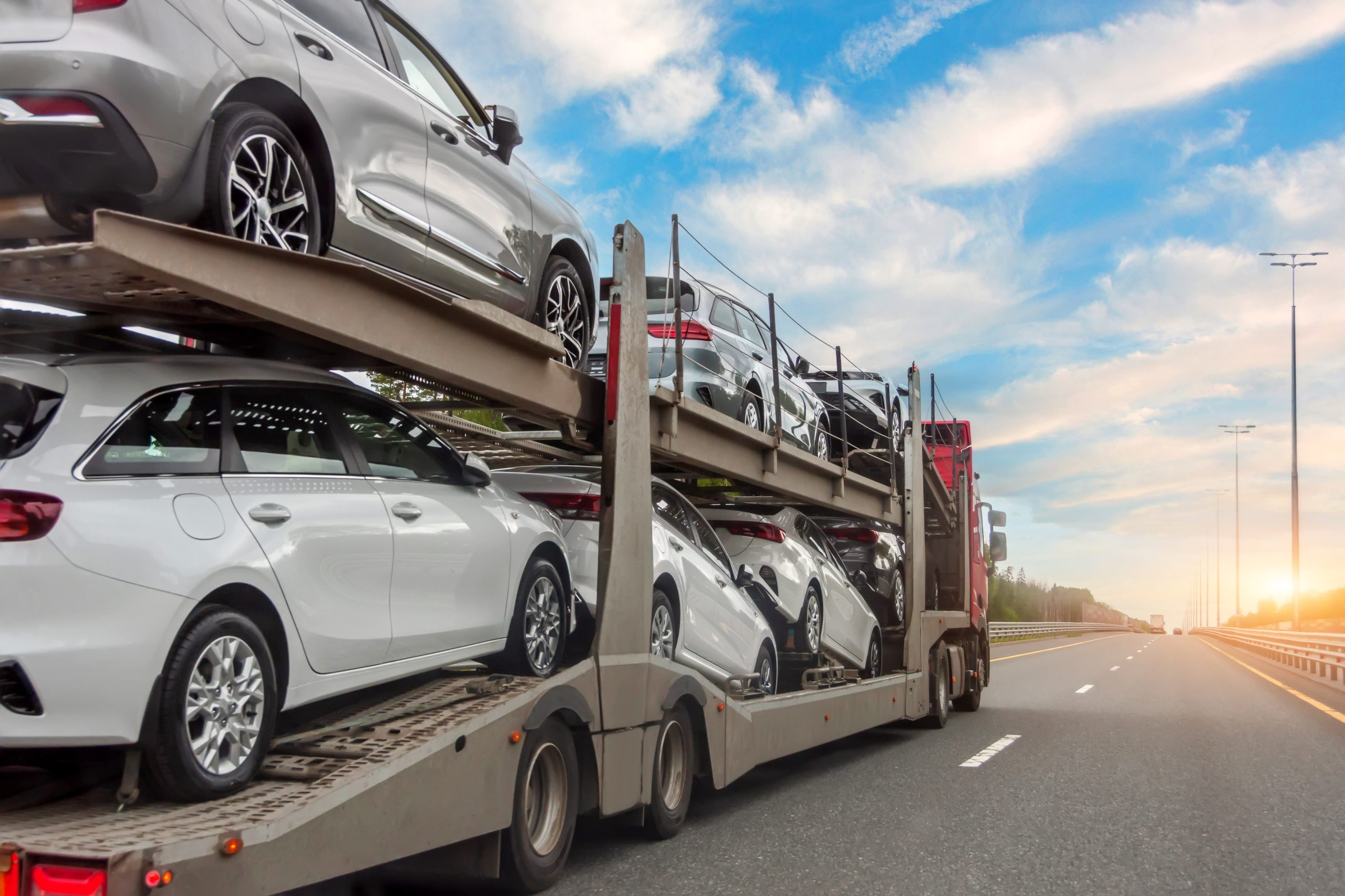 Transportation of new and very expensive cars. Hauling cars trailer and truck pulls rides on the highway.