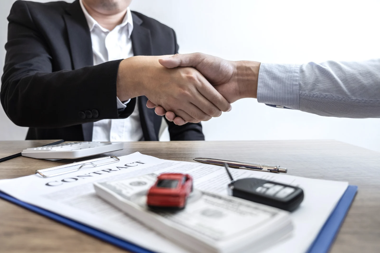 Two people shaking hands in agreement over car shipping insurance and costs. 