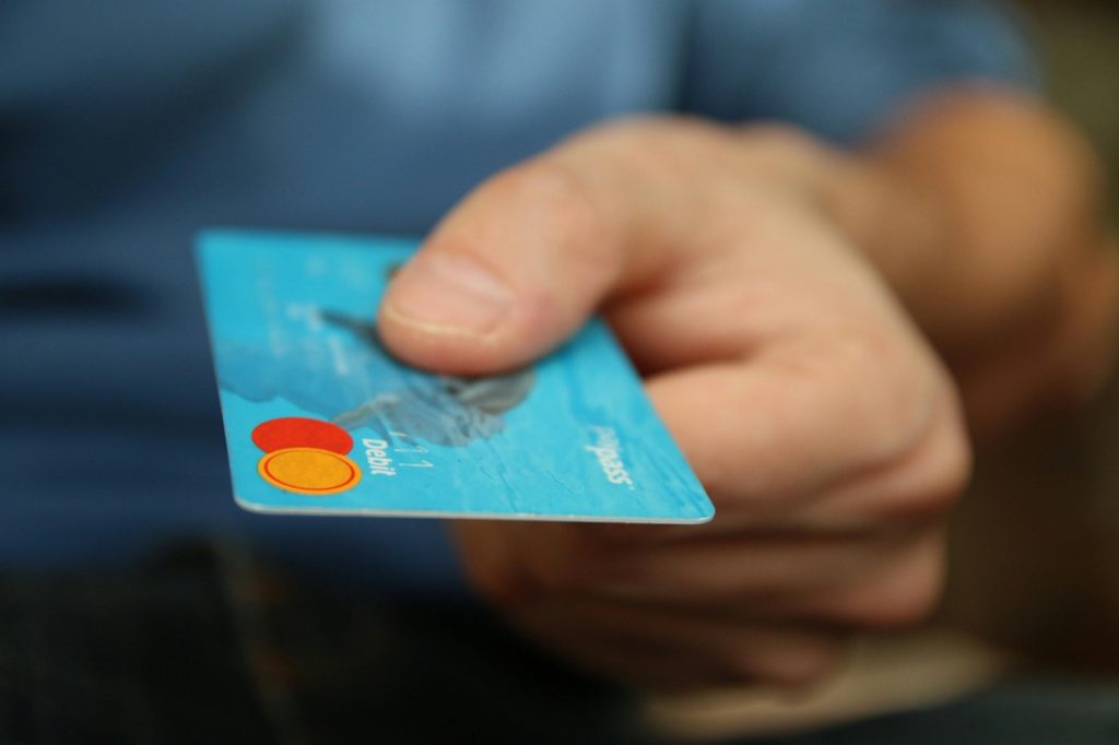Person holding credit card to pay for car shipping services.